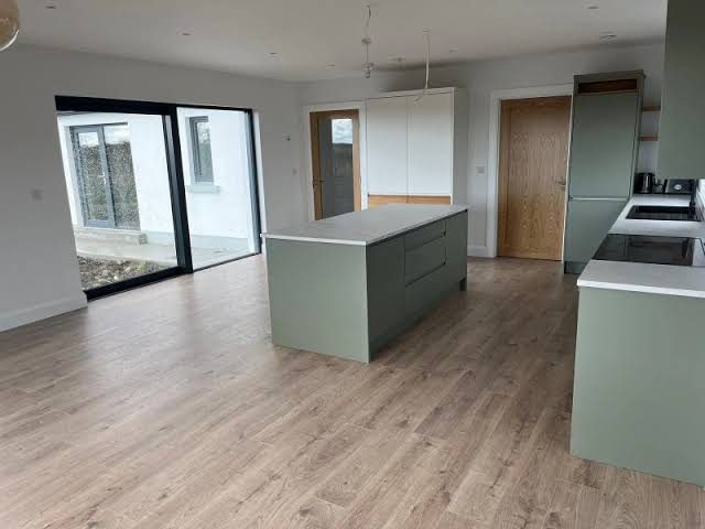 Kitchen with sage green island and sliding patio doors